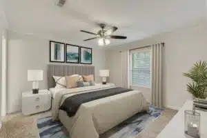 A modern bedroom with a large bed, two nightstands with lamps, a ceiling fan, a window with curtains, abstract artwork above the bed, and a decorative rug.